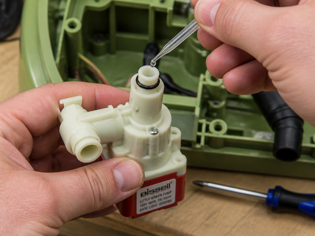Close-up of replacing a Bissell Little Green water pump and lubricating O-ring.